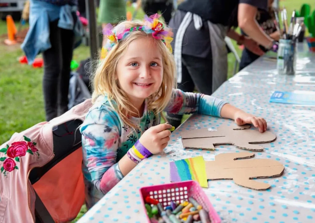 children being creative at the arts and crafts zone at a community event.