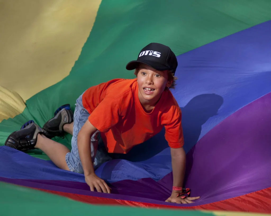 Parachute games in our Active play zone at a school holiday program at Elements of Byron Resort Byron Bay