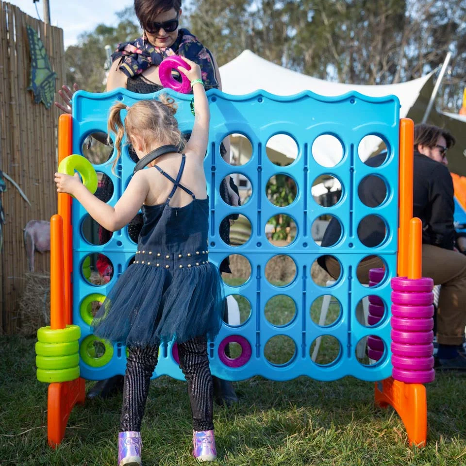 Families enjoying playing giant games at a family friendly event organised by kidzklub Australia.