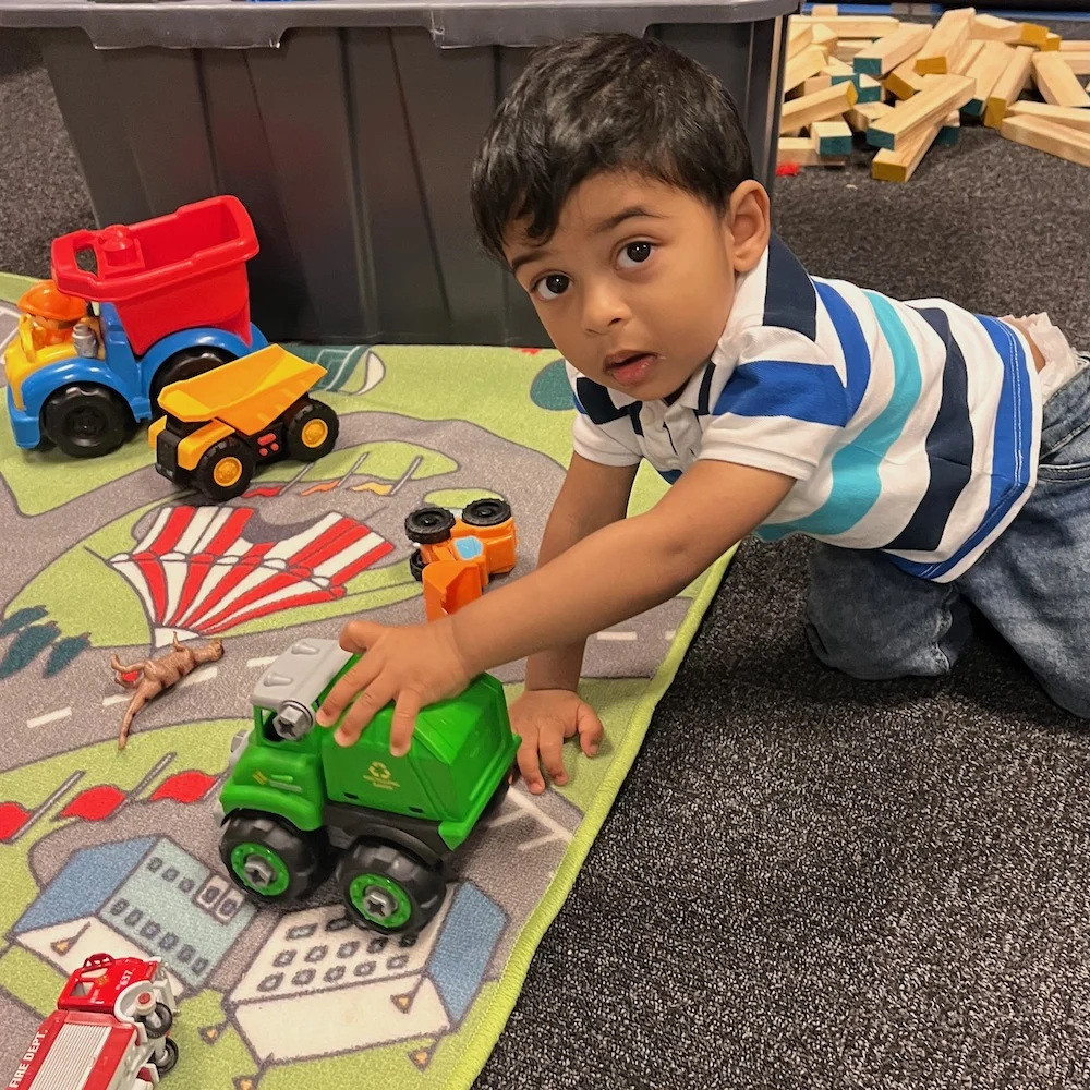 Little boy playing on the car mat at a corporate event childcare
